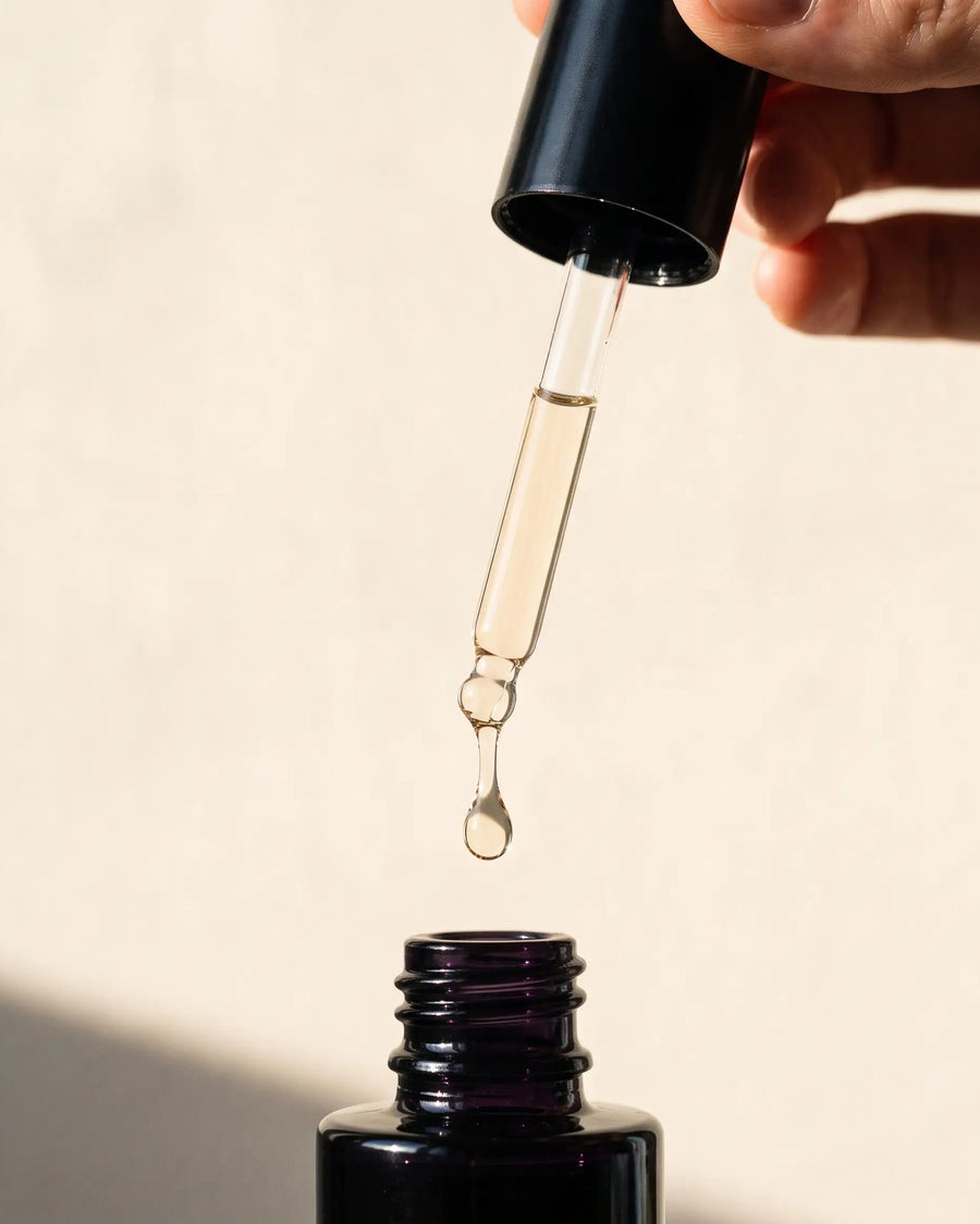 Goutte de sérum Pozone tombant de la pipette au-dessus du flacon